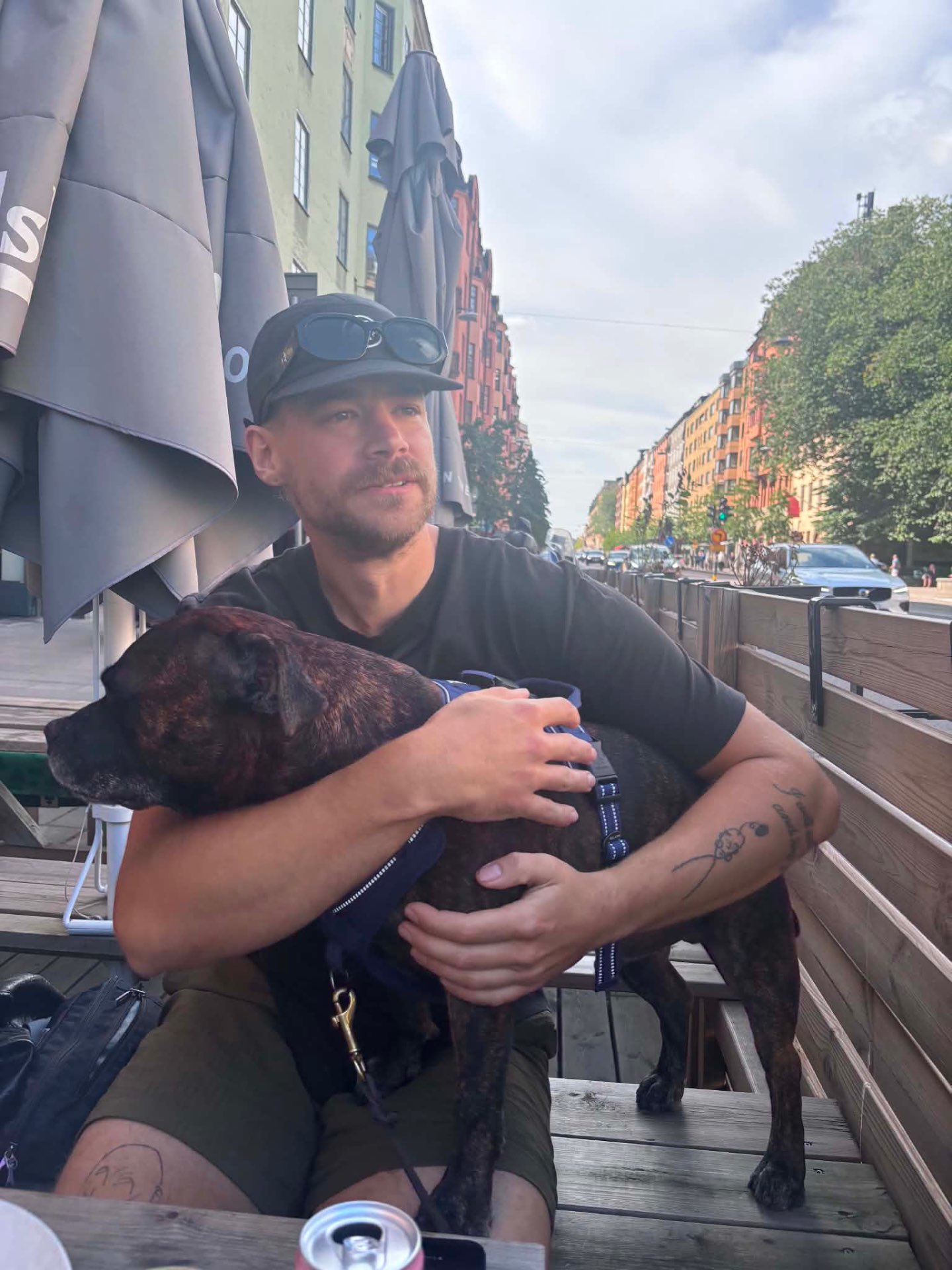 Rasmus som sitter på en bänk och kramar om sin mammas hund, Rey
